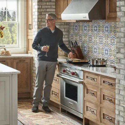 man with glasses in front of dual fuel stove
